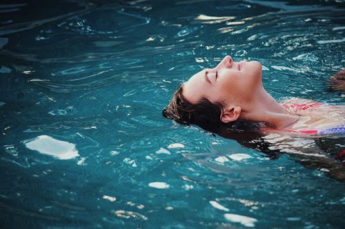 Jeune femme qui se détend dans une piscine pendant une cure thermale